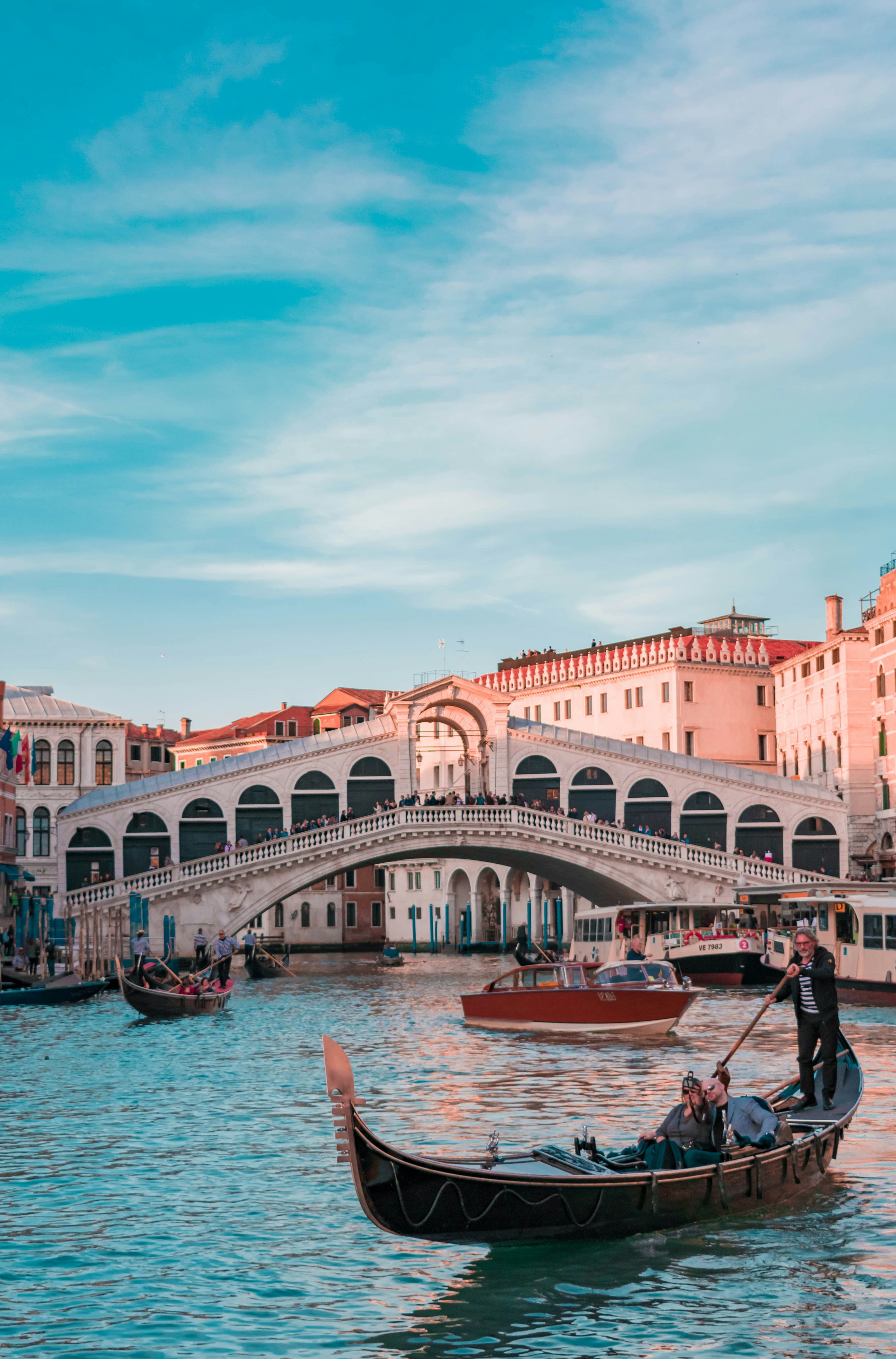 Rialto Bridge over the Grand Canal in Venice with gondolas at golden hour