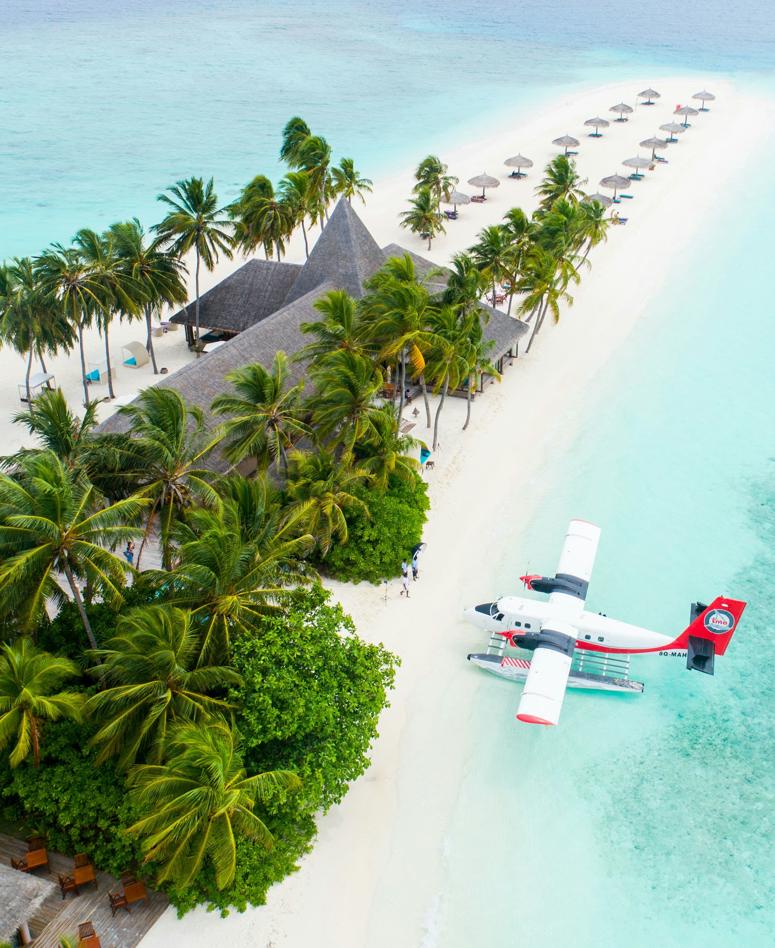 Aerial view of a tropical Maldives resort island with a seaplane on the beach