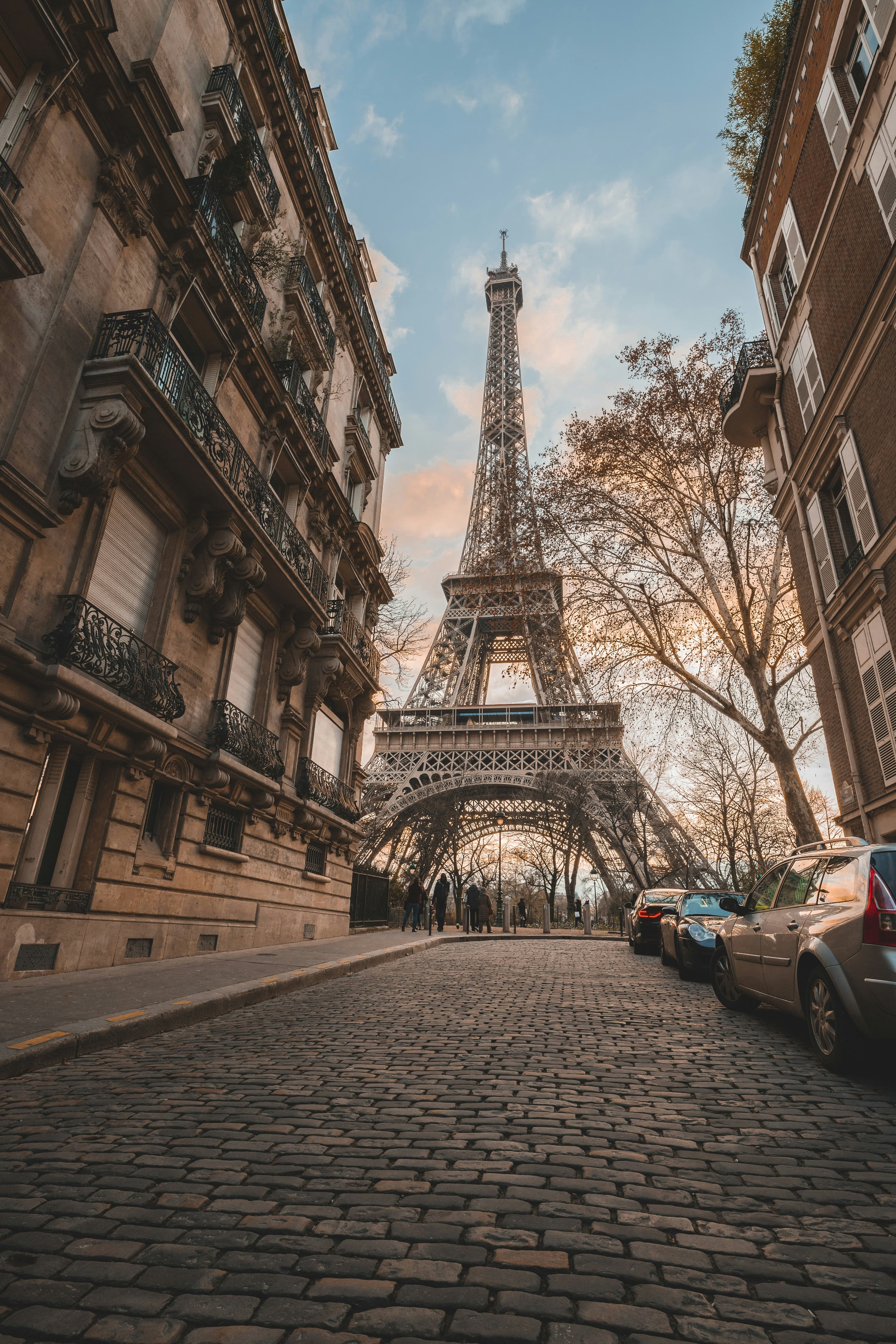 Cobblestone Parisian street leading to the Eiffel Tower at sunset