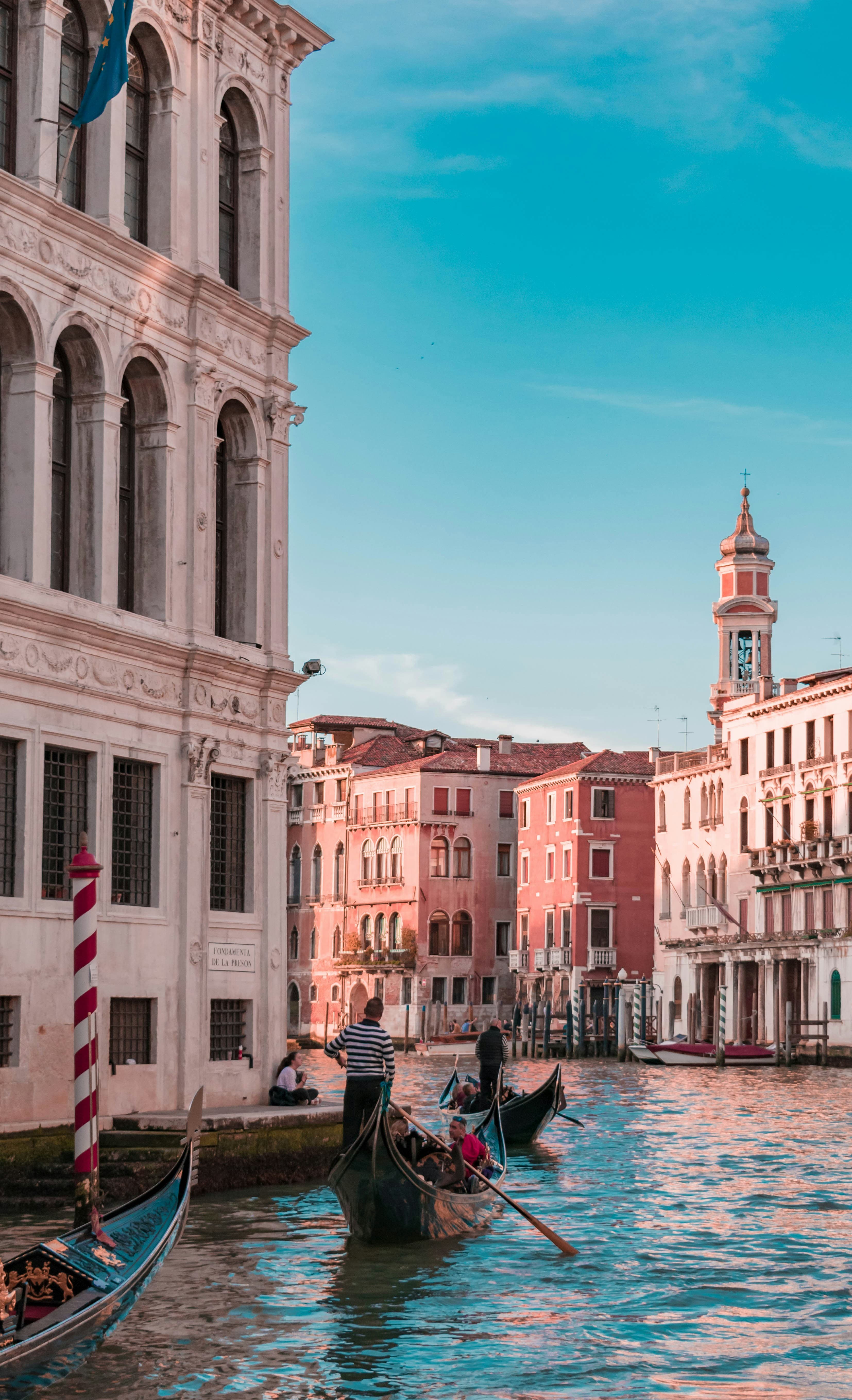 Gondolas gliding along a Venetian canal lined with historic buildings